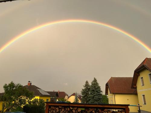 a rainbow in the sky over some houses at Ferienhaus Rabl in Rosenburg