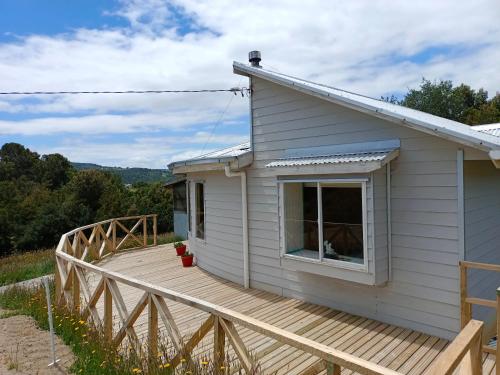 a house with a wooden deck in front of it at Cabaña Chepu in Ancud