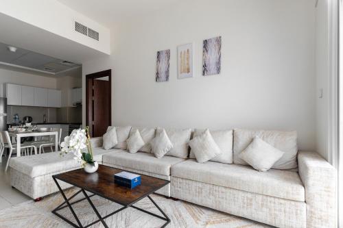 a living room with a couch and a table at Simply Comfort Vacation Homes Rental Binghatti Gateway Family 2BR with Balcony, Close to Dubai Mall & Burj Khalifa in Dubai