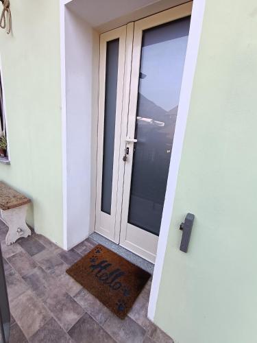 a glass door with a welcome mat in front of it at Come una barca nel bosco in Villar Perosa
