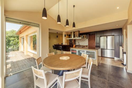 a kitchen and dining room with a wooden table and chairs at La Villa Bleue, Luxe, Piscine et Spa in Capdenac