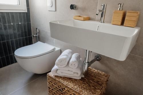 a bathroom with a sink and a toilet and towels at Donna Rita in Monopoli