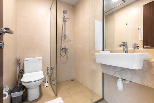 a bathroom with a toilet and a sink and a shower at Simply Comfort Vacation Homes Rental Binghatti Gateway Family 2BR with Balcony, Close to Dubai Mall & Burj Khalifa in Dubai