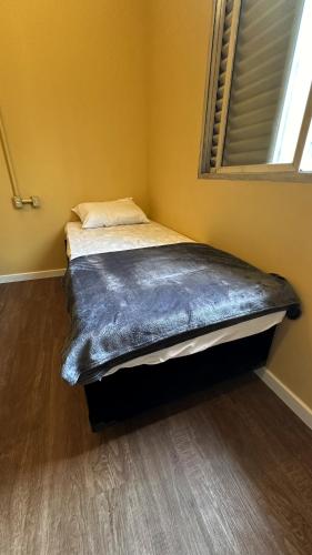 a bed sitting in a room with a window at Hostel Distrito 011 in Sao Paulo