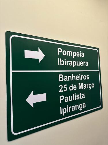 a green street sign with arrows on a wall at Hostel Distrito 011 in Sao Paulo