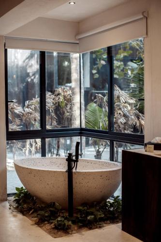 a bathroom with a large stone sink in front of a window at UMi Tulum in Tulum