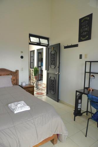 a bedroom with a bed and a door with a sign at Casa San Cristóbal in San Cristóbal de Las Casas