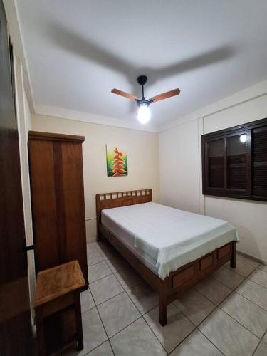 una camera da letto con un letto e un ventilatore a soffitto di Chalé Carvalho - Salmão a Itapoa