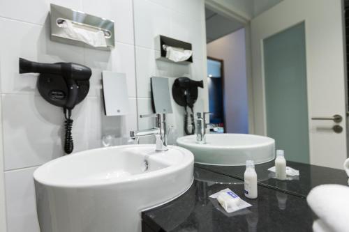 a bathroom with a sink and a phone on the wall at Holiday Inn Express - Marseille Airport by IHG in Vitrolles