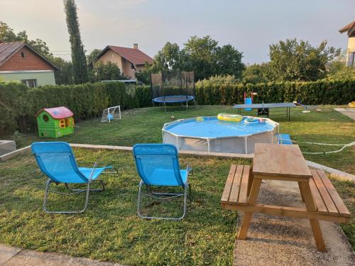 a backyard with a table and chairs and a trampoline at Vila Pogled in Novi Sad