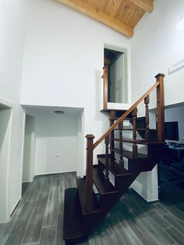 a staircase in a house with wooden floors at Ervis Villa in Sheaj