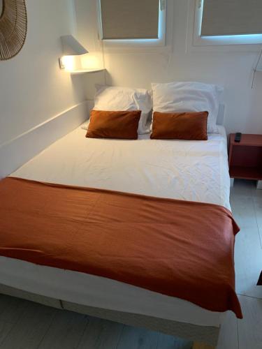 un lit avec deux oreillers dessus dans une chambre dans l'établissement CAP Estérel FH007 , PISCINE CHAUFFÉE DU 05 avril au 02 Novembre , superbe parc aquatique ,Animations restaurants,boutiques, activités sportives village Club tout inclus, à Saint-Raphaël