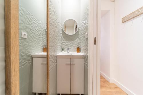 une salle de bain avec un lavabo et un miroir dans l'établissement Le Marietton appartement cosy à deux pas du métro Valmy, à Lyon