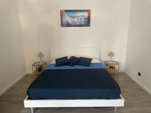 a bedroom with a blue bed with two tables at Maison Margot in Pozzuoli