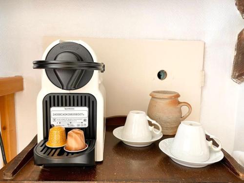 - une cafetière assise sur une table avec des assiettes et des tasses dans l'établissement La bonne qui revait d opera, à Tours