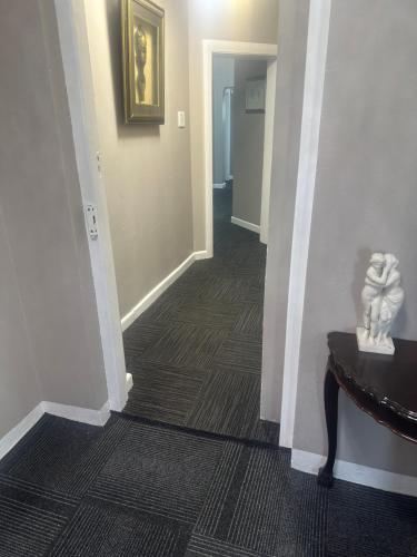a hallway with a stairway with a statue on a table at Prime Executive Accommodation in Cape Town