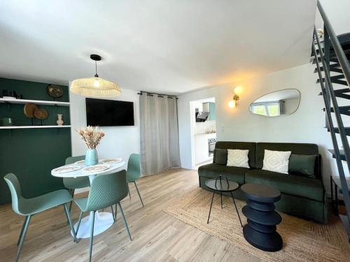 un salon avec un canapé, une table et des chaises dans l'établissement Duplex rénové secteur Lac d'Enghien, à Saint-Gratien