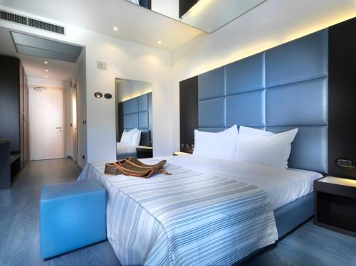 a bedroom with a large white bed with a blue headboard at Blu9 Hotel in Novedrate