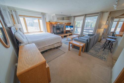 a bedroom with a bed and a living room at Lenawee 1728 by SummitCove Lodging in Keystone