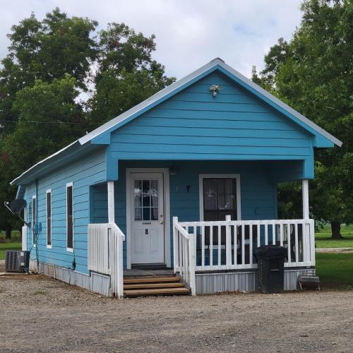 a blue tiny house with a porch and stairs at Turn On Inn in Lake Village