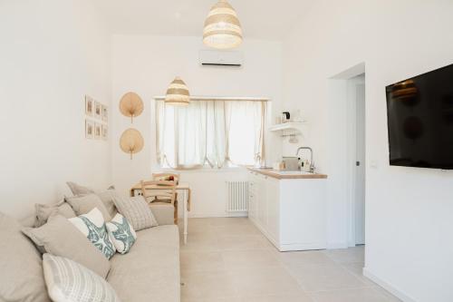 a white living room with a couch and a kitchen at Donna Rita in Monopoli