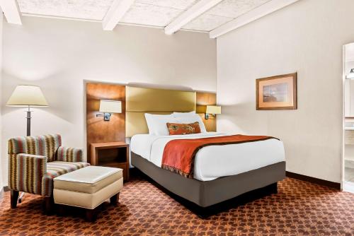 a hotel room with a bed and a chair at Best Western Outlaw Inn in Rock Springs
