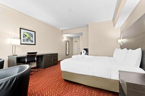 a hotel room with a large bed and a desk at Best Western Inn On The Bay in Owen Sound