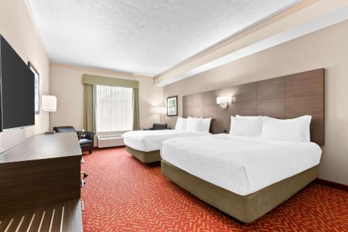 a hotel room with two beds and a flat screen tv at Best Western Inn On The Bay in Owen Sound