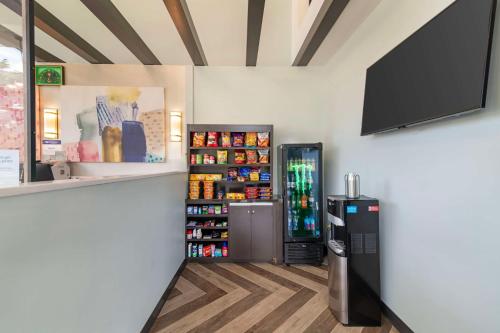 a room with a refrigerator and a flat screen tv at Best Western Plus Landmark Inn in Laconia