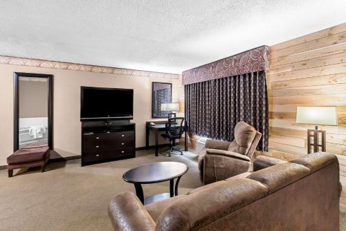 a living room with a couch and a television at Heartland Inn & Suites, SureStay Collection by Best Western in Park Rapids