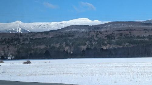 a snow covered mountain in the distance with a lake at Charming Stowe Retreat with Mountain Views home in Stowe