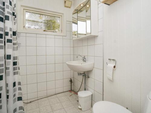 a white bathroom with a sink and a toilet at Charming Cottage by Beach - By Traum Ferienwohnungen in Skibby