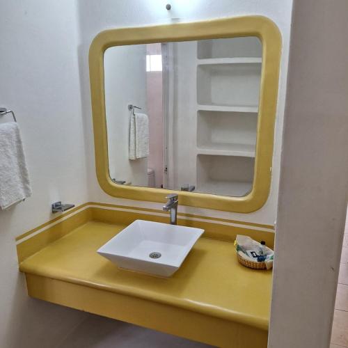 a bathroom with a sink and a mirror at Hotel Anturios in Zihuatanejo