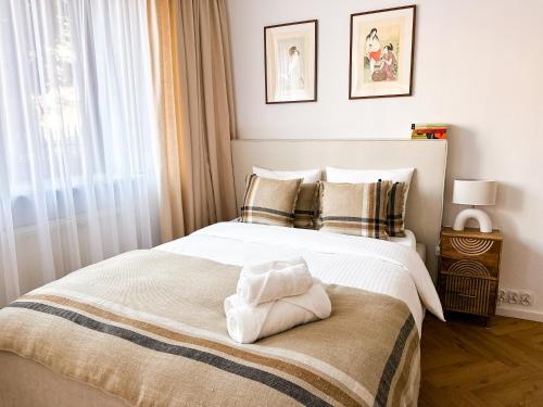 a bedroom with a bed with a towel on it at FLH Boutique Studio in Warsaw