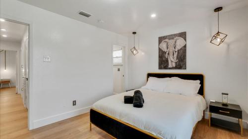 a white bedroom with a bed with a black headboard at Holiday 4BR 2BA Home with Pool, Hot Tub, Fire Pit in Irving