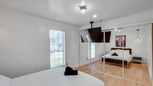 a white bedroom with a bed and a tv at Holiday 4BR 2BA Home with Pool, Hot Tub, Fire Pit in Irving
