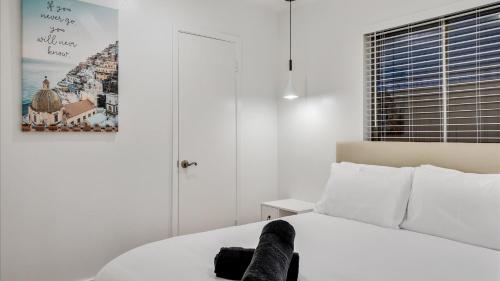 a bedroom with a white bed and a picture on the wall at Holiday 4BR 2BA Home with Pool, Hot Tub, Fire Pit in Irving