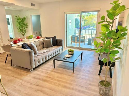 a living room with a couch and a table at Corner 2 Bedroom 2 Bath Condo - Balcony - Parking in Los Angeles