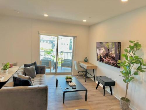 a living room with a couch and a table at Corner 2 Bedroom 2 Bath Condo - Balcony - Parking in Los Angeles