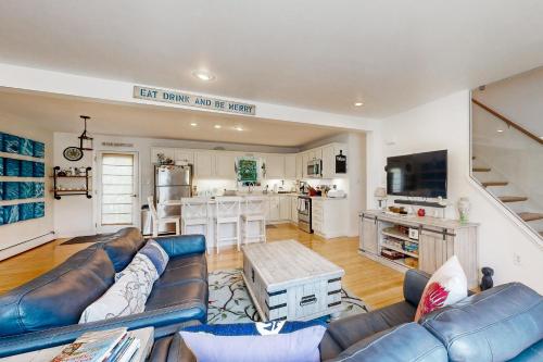 a living room with a blue couch and a kitchen at Bird Street Breeze in Oak Bluffs