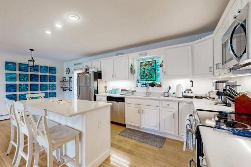 a kitchen with white cabinets and a kitchen island at Bird Street Breeze in Oak Bluffs