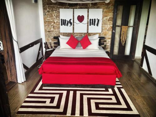 a bedroom with a large bed with red pillows at Romance in Ella in Ella