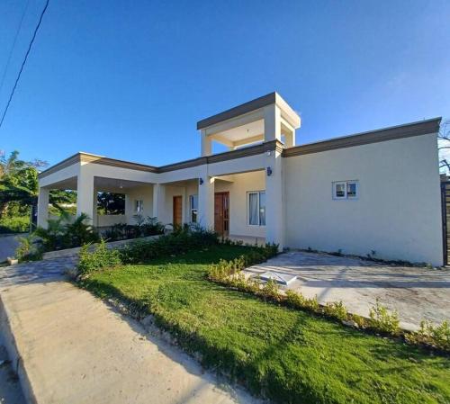 a large white house with a grass yard at Villa Xiomara in El Jamo