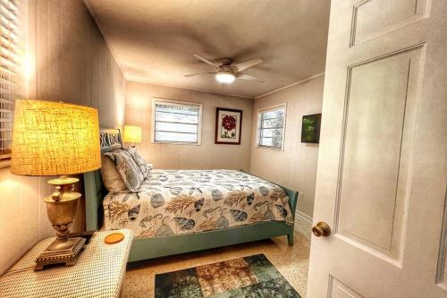 ein Schlafzimmer mit einem Bett und einem Deckenventilator in der Unterkunft Cute Cottage with 3 min walk to beach with bikes! in Jekyll Island