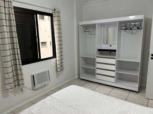 a white room with a window and a windowpect at Apto confortável, Praia das Astúrias 5 min a pé, garagem, 2 quarto ar, suíte, wi-fi in Guarujá