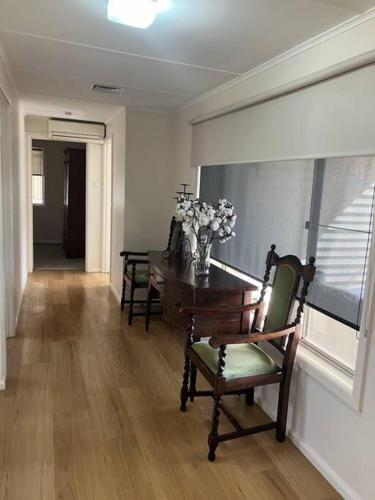 a dining room with a table and chairs and a window at BnB on Church in Hay
