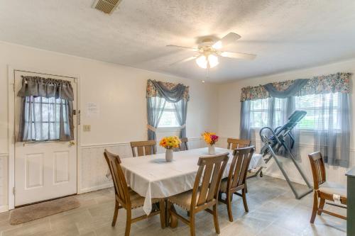 a dining room with a table and chairs and a fan at Cozy Waycross House with Yard and Screened Patio! in Waycross