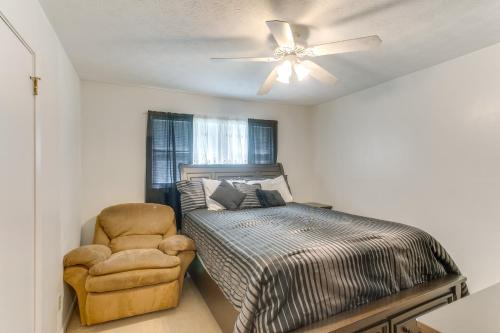 a bedroom with a bed and a chair and a ceiling fan at Cozy Waycross House with Yard and Screened Patio! in Waycross