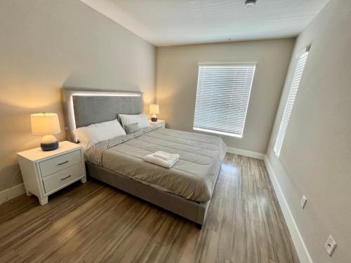 a bedroom with a bed and a nightstand and a window at Spacious 2 Bedroom 2 Bathroom In Gated Community in Los Angeles