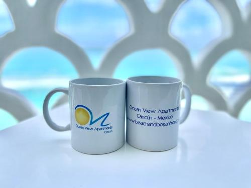 Dos tazas de café blancas una al lado de la otra en Beachside Apartments Cancun, en Cancún